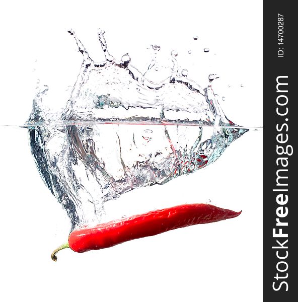Red hot chili pepper splashing into water isolated on white. Red hot chili pepper splashing into water isolated on white