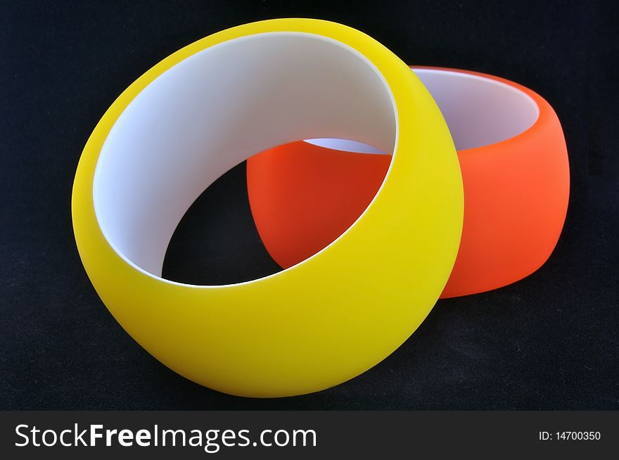 Yellow and orange polymer bracelets on black background. Yellow and orange polymer bracelets on black background