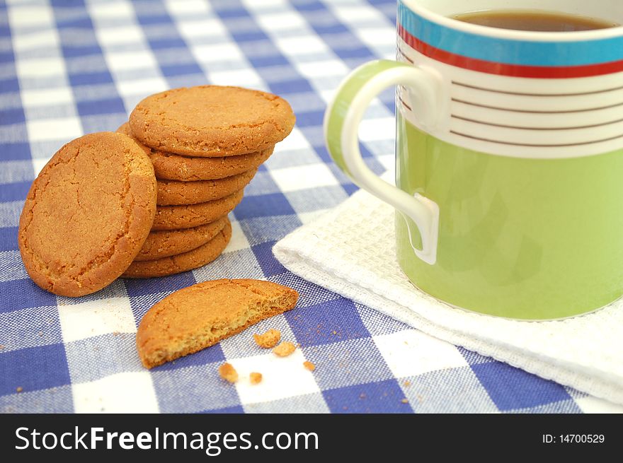 Stack of biscuits with a cup of coffee on a chequered tablecloth. Stack of biscuits with a cup of coffee on a chequered tablecloth