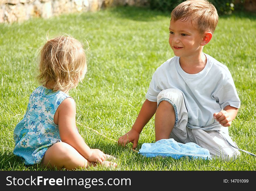 Two kids playing on green grass