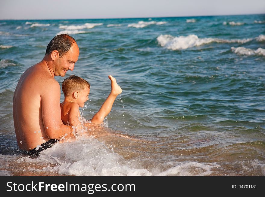 Father and son playing in water. Father and son playing in water