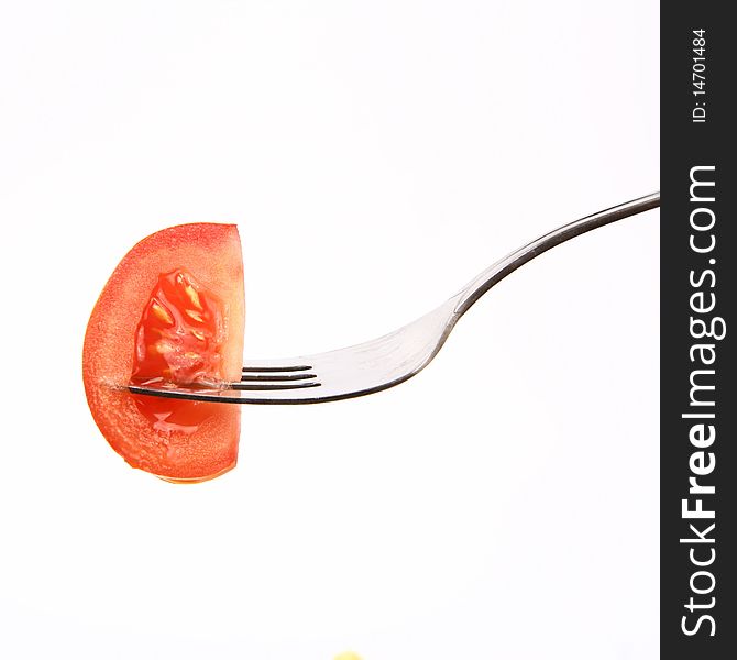 Piece of tomato on fork on white background