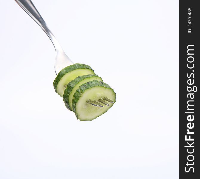 Three slices of cucumber on white background