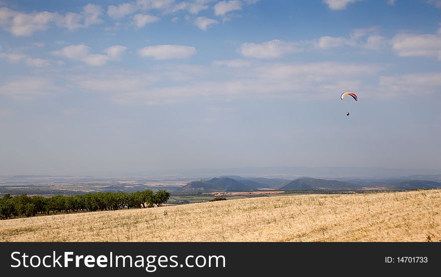 Paraglider flying over the field