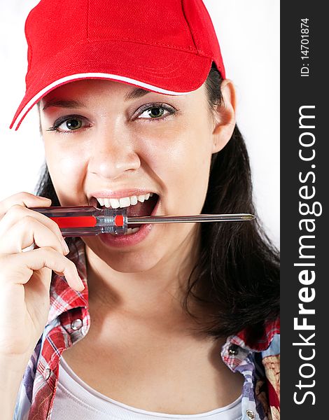 Carpenter girl holding a screwdriver in her mouth