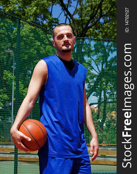 Young basketball player with ball on the sportground