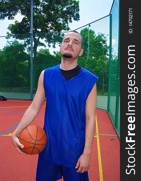 Young basketball player with ball on the sportground