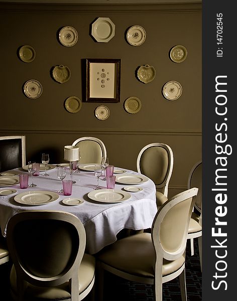 Restaurant table with decorative plates on an olive green wall