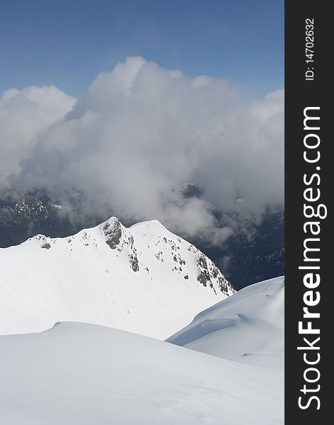 A mountain winter slope in clouds in a landscape with white snow. A mountain winter slope in clouds in a landscape with white snow.