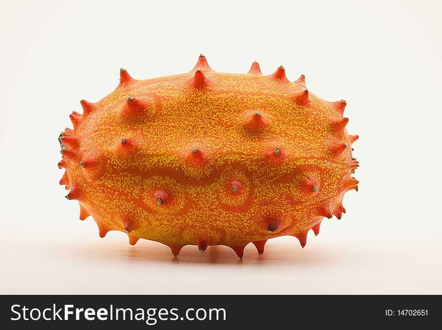 Whole horned melon, also known as Blowfish Fruit, on white background.