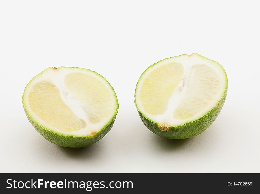 Two lime halves on white background