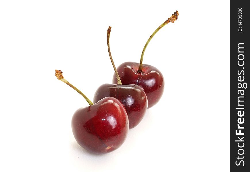 Three dark red cherry isolated in white. Three dark red cherry isolated in white