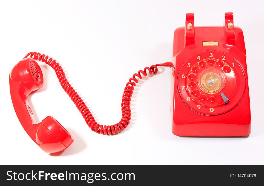 Classic 1970 - 1980 retro dial style red house telephone on white background