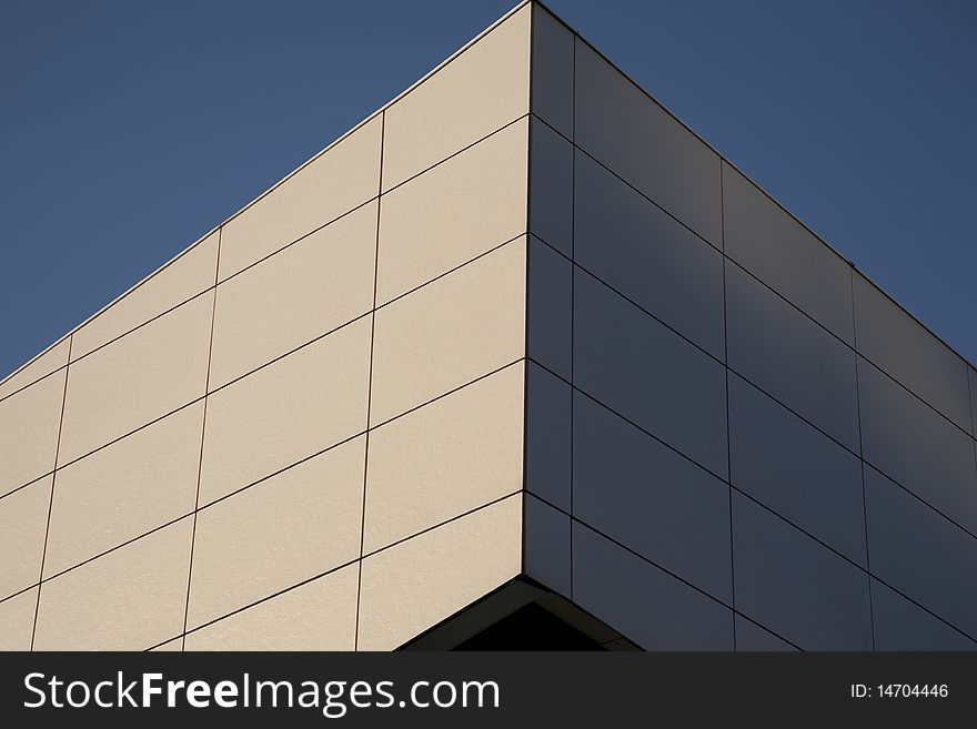 Closeup of white wall at angle against a blue sky background. Closeup of white wall at angle against a blue sky background