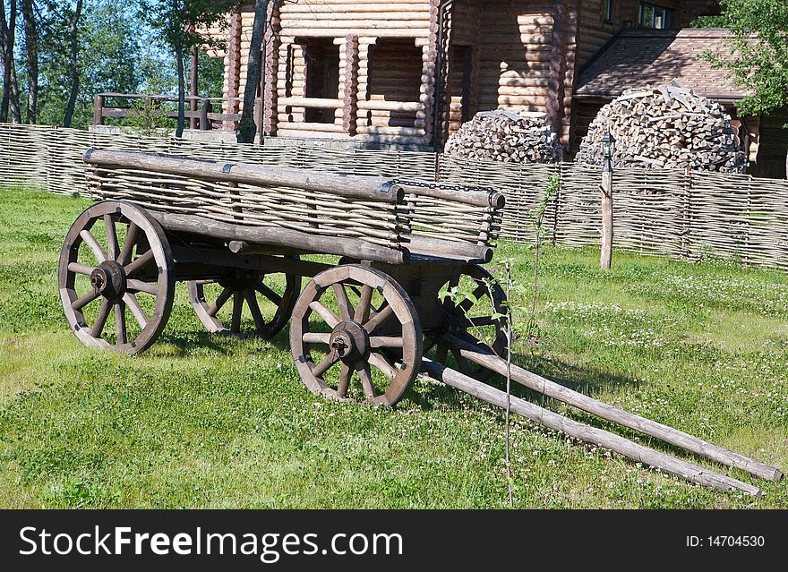 Wooden cart on a background of country house. Wooden cart on a background of country house.