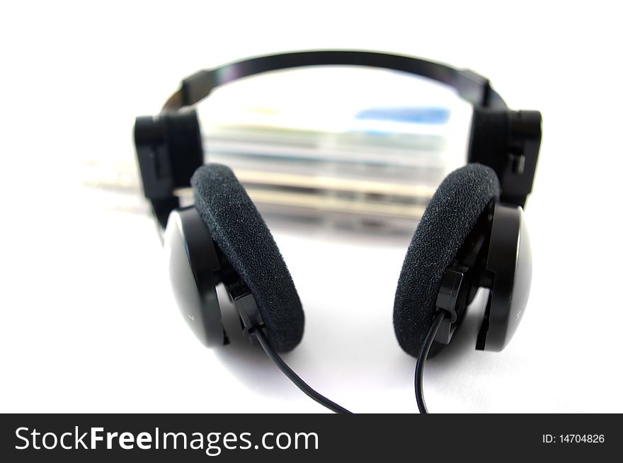 Headphones and compact disks on white background