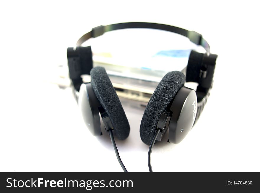 Headphones and compact disks on white background