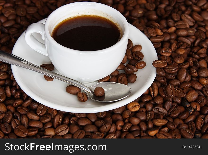 Cup of coffee on a background coffee grains