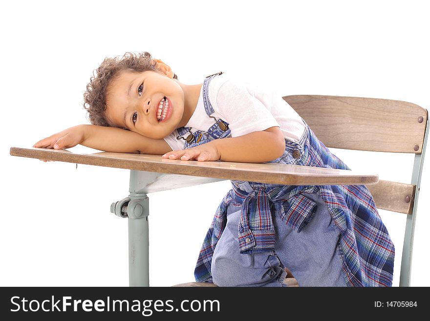 Adorable little boy sitting in a desk