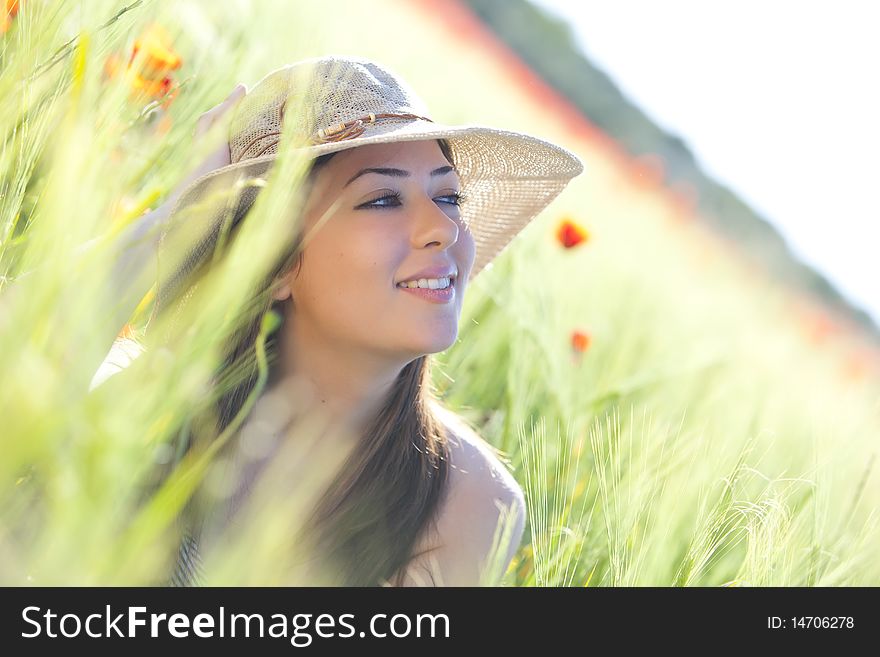 Young beautiful girl with hat staring and smiling at something. Young beautiful girl with hat staring and smiling at something