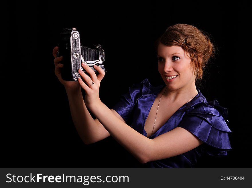 Beautiful woman with the old camera on a black background. Beautiful woman with the old camera on a black background