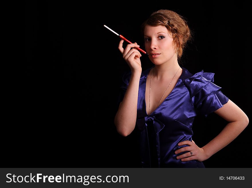 Young woman with a cigarette on a black background