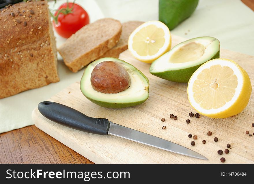 Sliced avocados and lemons on a chopping board. Sliced avocados and lemons on a chopping board