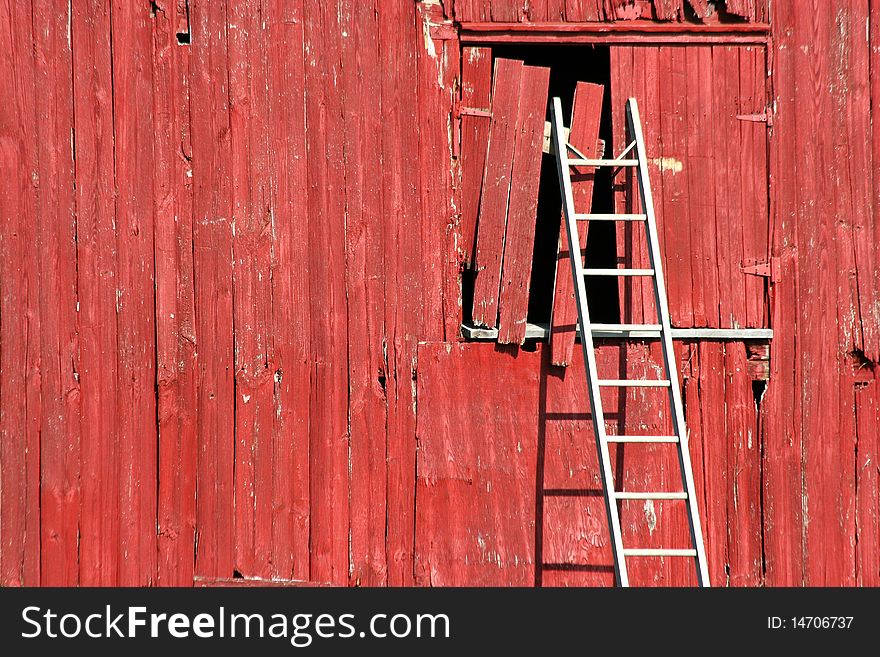 A ladder on a old red bard. A ladder on a old red bard