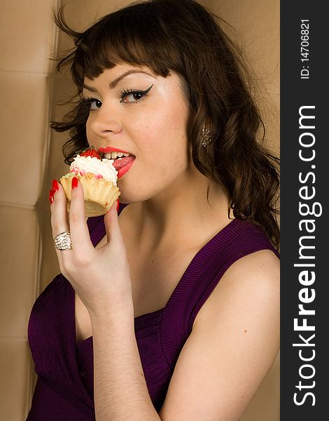 girl in violet dress is eating cake. girl in violet dress is eating cake