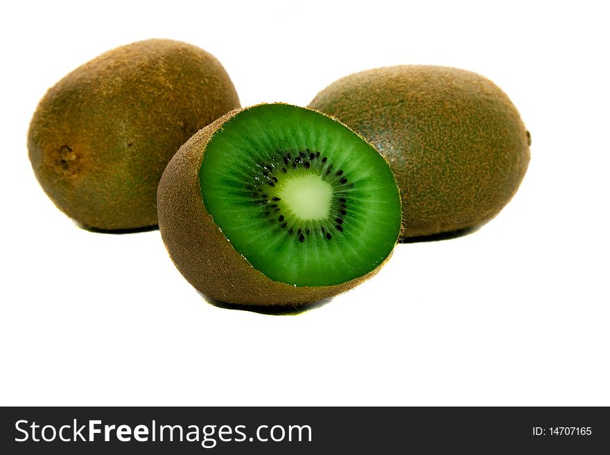 Three kiwi laying together, one of which is cut on two half. Three kiwi laying together, one of which is cut on two half