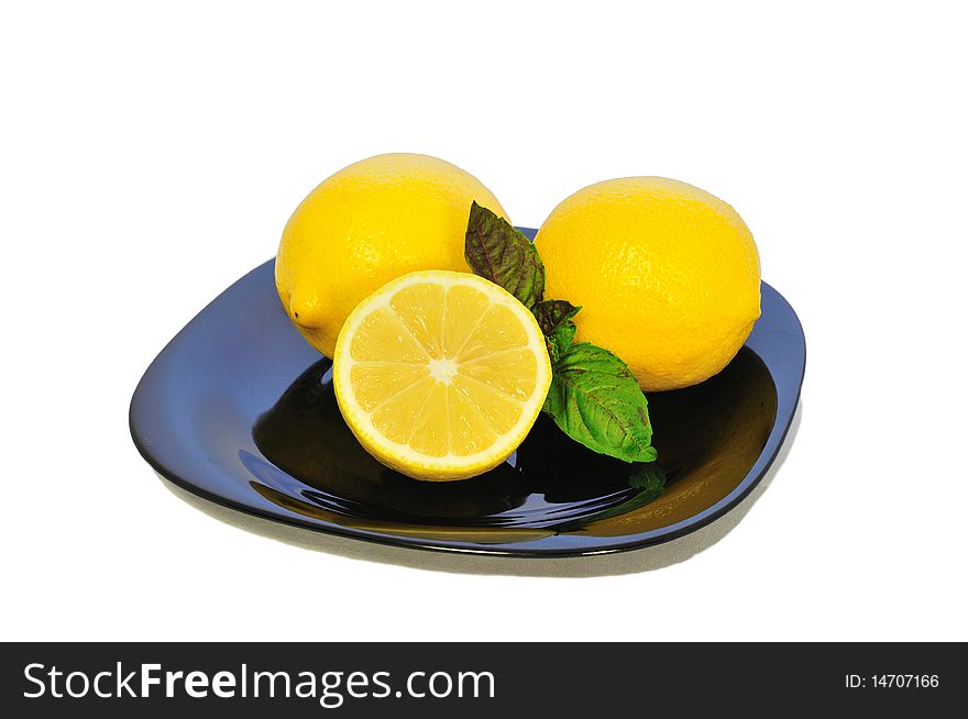 Isolated Yellow lemons on the black plate. Isolated Yellow lemons on the black plate