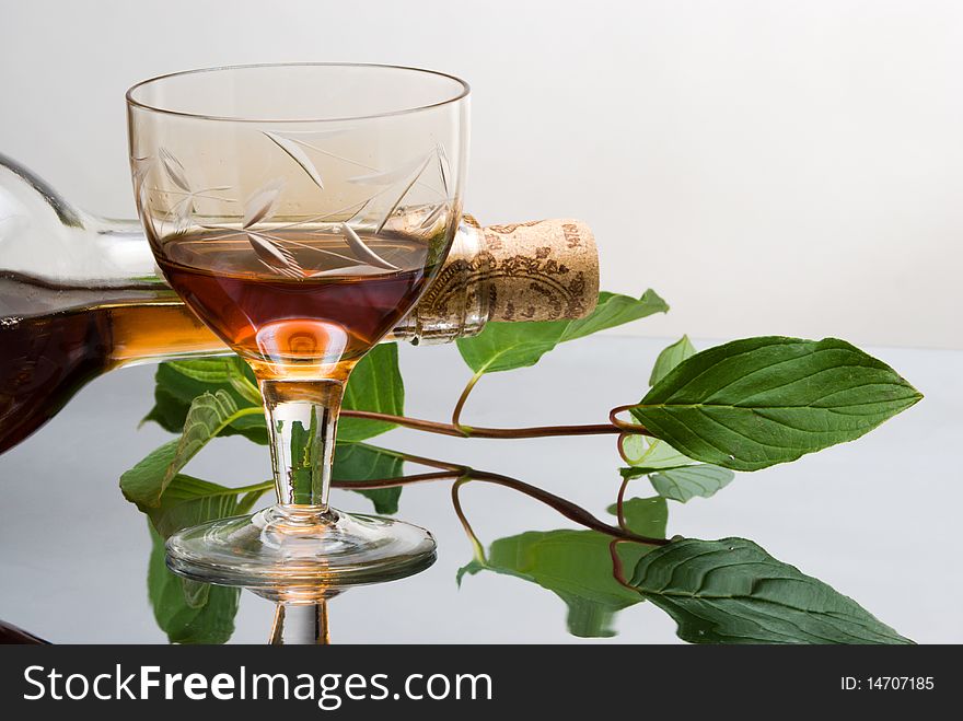 Glass of red wine near wine bottle