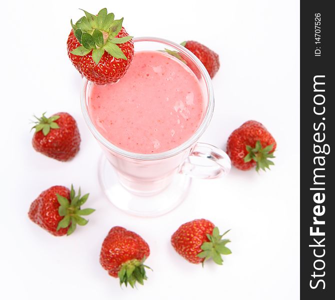 Strawberry shake in a glass decorated with strawberries on white background