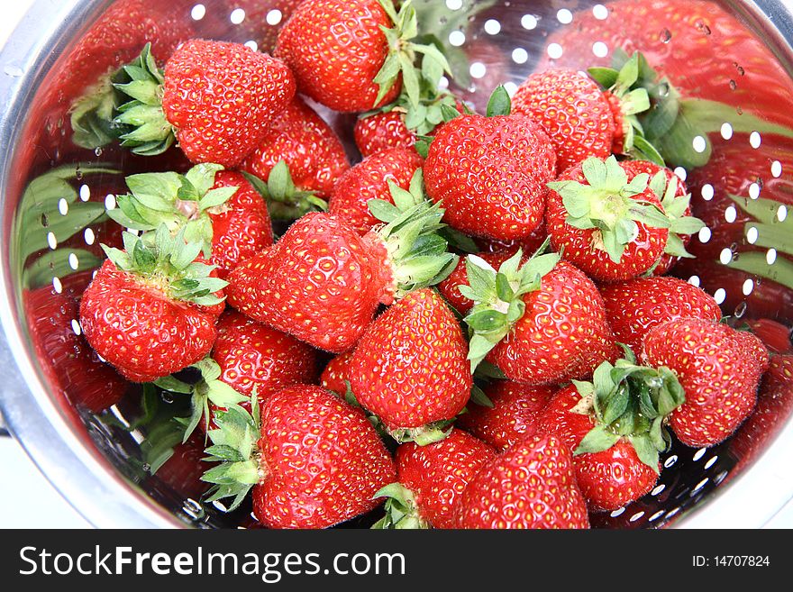 Fresh strawberries in a colander in close up