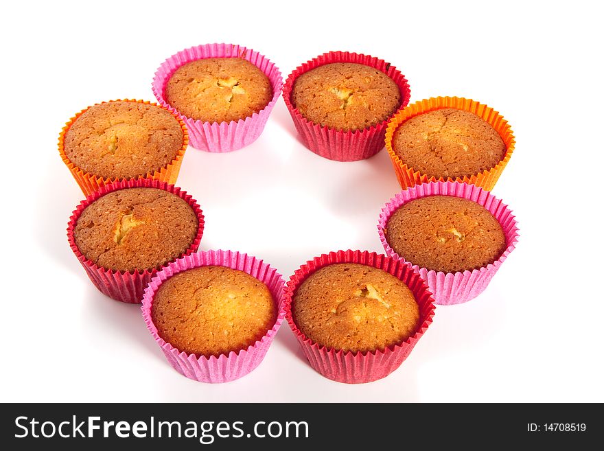 Colorful baked cupcakes in a circle isolated over a white background