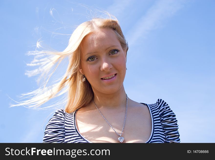 Blond girl posing in nature with sky in background