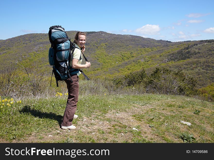 Hicker girl with backpack in mountains