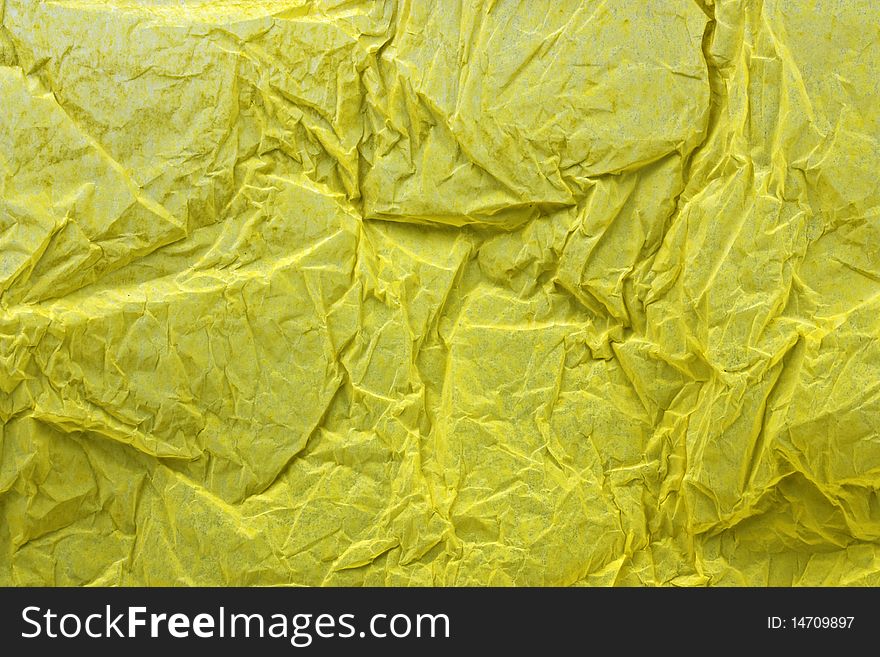 an abstract background of creased yellow tissue paper. an abstract background of creased yellow tissue paper