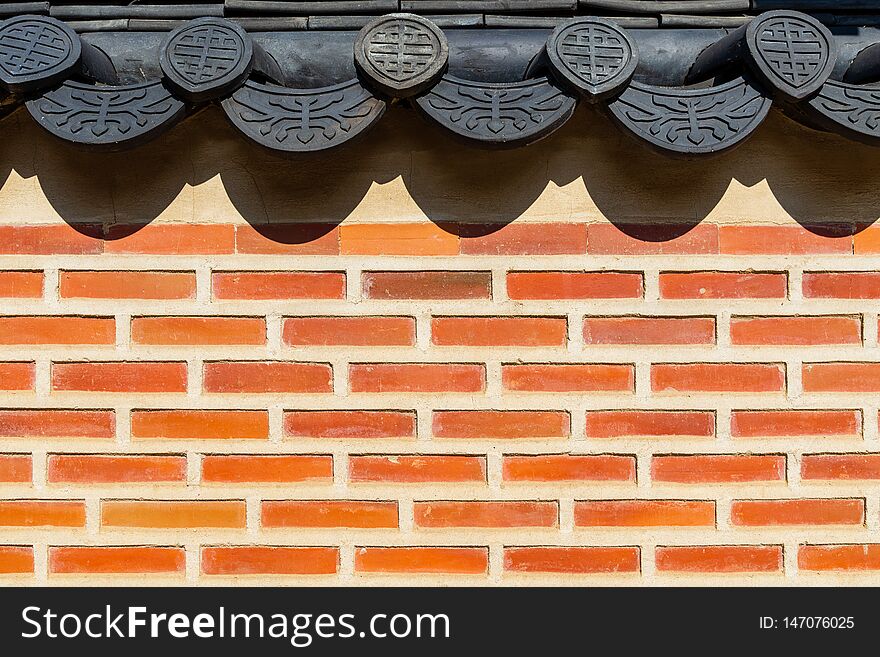 Traditional Korean brick wall and black ceramic roof at Gyeongbokgung Palace, Seoul, South Korea - close up view with space for design or text. Traditional Korean brick wall and black ceramic roof at Gyeongbokgung Palace, Seoul, South Korea - close up view with space for design or text