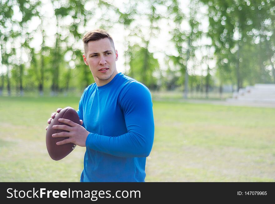 Portrait of a young american football player with a ball in training