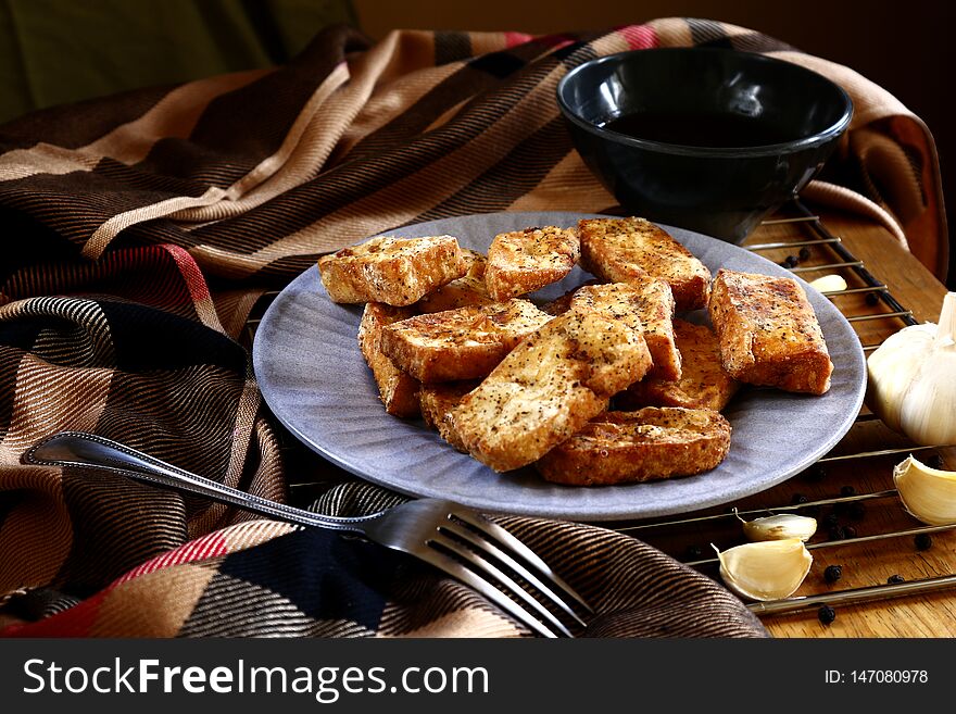 Photo of hot and fresh, fried crispy tofu on a wooden table