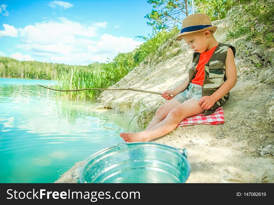 A happy child fishes off the coast in nature