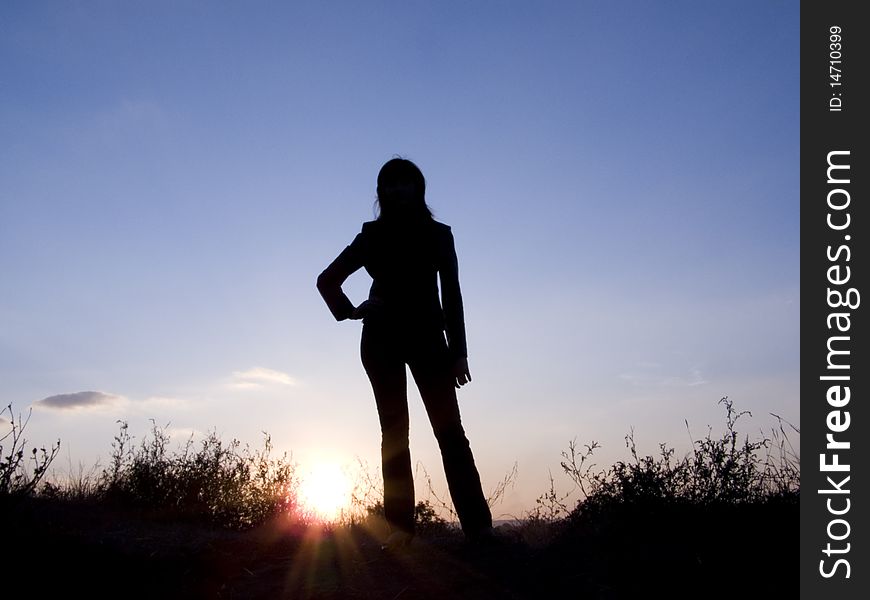 A silhouette of young girl is on a background sky. A silhouette of young girl is on a background sky.