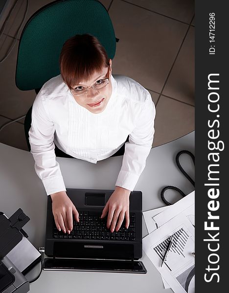 Young business woman working on a laptop at his desk in the office