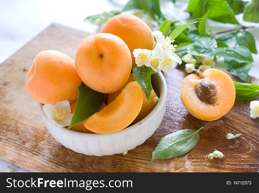 Fresh apricots in bowl on table