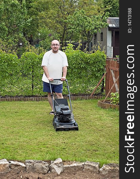 Man cutting grass at suburban house