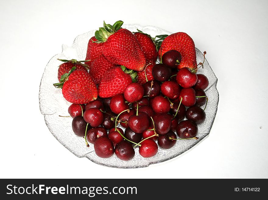 Cherry and strawberry on the dish on white background. Cherry and strawberry on the dish on white background
