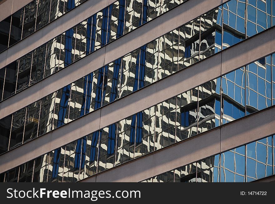 Reflections of a skyscraper in the windows of an office building. Reflections of a skyscraper in the windows of an office building