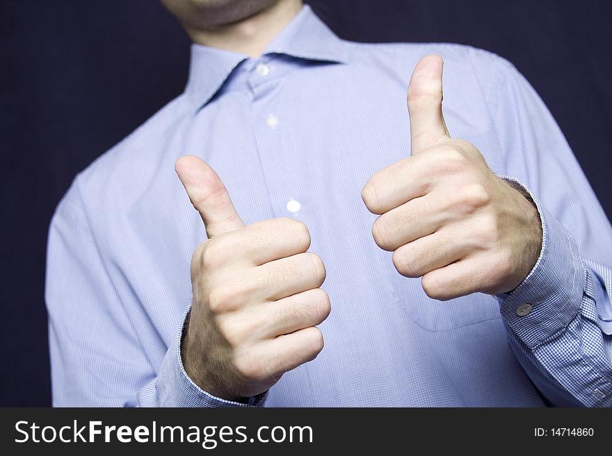 Happy young businessman in a blue shirt with a finger gesture OK. Happy young businessman in a blue shirt with a finger gesture OK