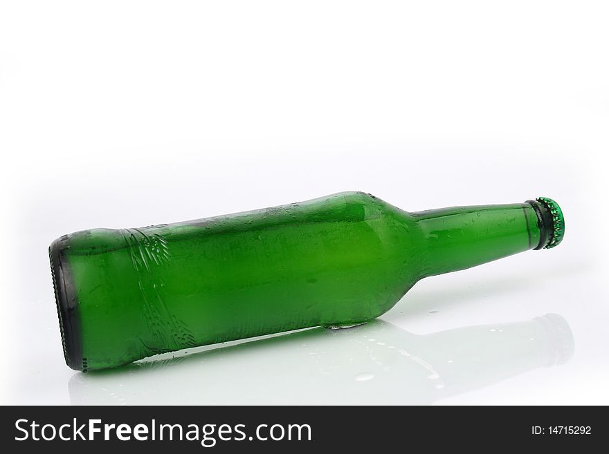A bottle of beer is slanted with white background